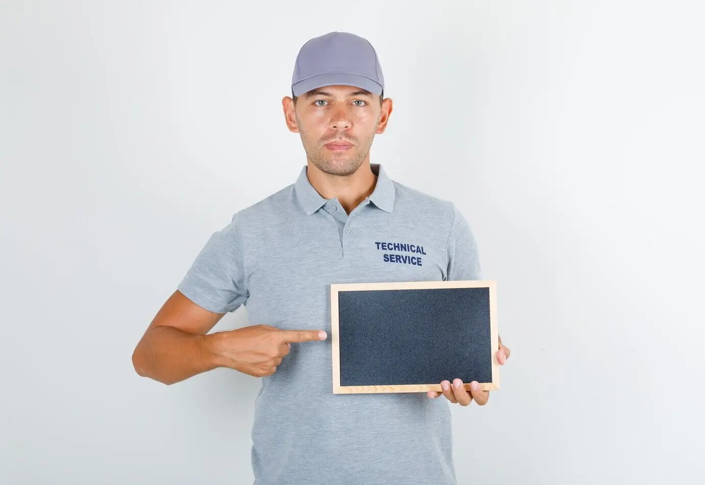 Technischer Servicemitarbeiter in grauem T-Shirt mit Kappe, der eine schwarze Tafel hält